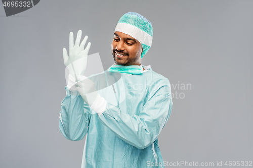 Image of indian male doctor or surgeon putting glove on