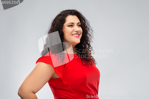 Image of happy woman in red dress over grey background