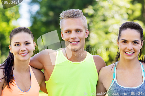 Image of group of happy friends or sportsmen at summer park