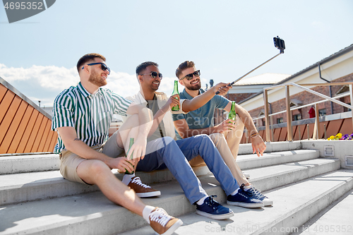 Image of men drinking beer and taking selfie by smartphone