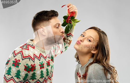 Image of happy couple kissing under the mistletoe