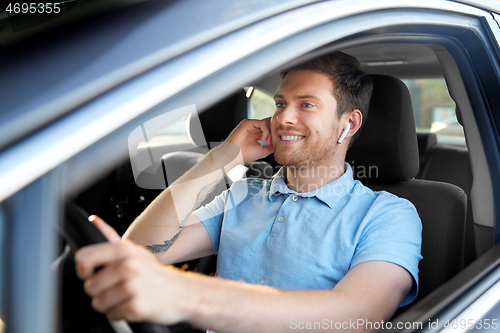 Image of man or driver with wireless earphones driving car