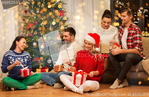 Image of friends celebrating christmas and opening presents