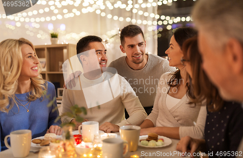 Image of happy family having tea party at home