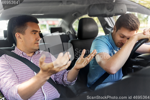Image of car driving instructor talking to man failed exam