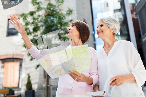 Image of senior women with city guide and map on street