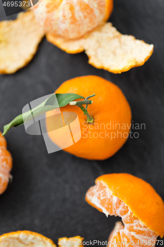 Image of close up of peeled mandarins on slate table top