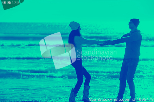 Image of Loving young couple on a beach at autumn sunny day