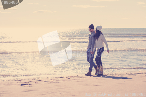 Image of Loving young couple on a beach at autumn sunny day