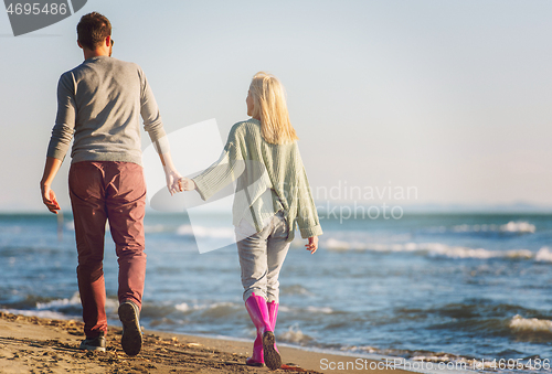 Image of Loving young couple on a beach at autumn sunny day