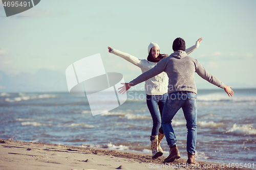 Image of Loving young couple on a beach at autumn sunny day