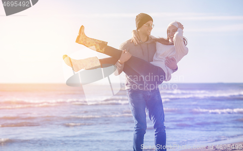 Image of Loving young couple on a beach at autumn sunny day