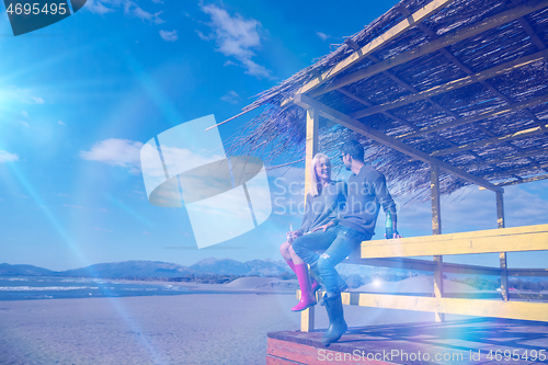 Image of young couple drinking beer together at the beach