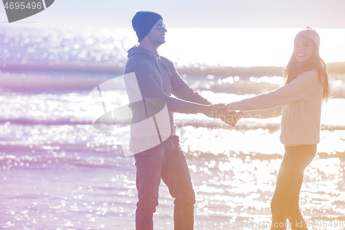 Image of Loving young couple on a beach at autumn sunny day