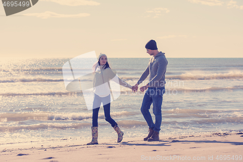 Image of Loving young couple on a beach at autumn sunny day