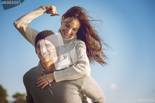 Image of couple having fun at beach during autumn