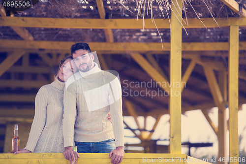 Image of young couple drinking beer together at the beach