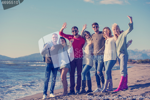 Image of portrait of friends having fun on beach during autumn day