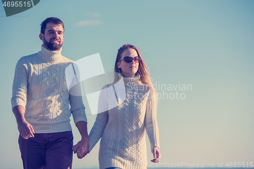 Image of Loving young couple on a beach at autumn sunny day