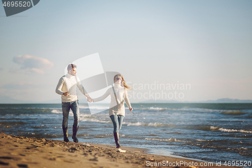 Image of Loving young couple on a beach at autumn sunny day