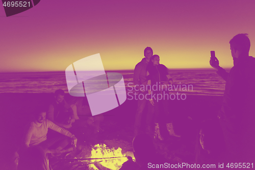 Image of Friends having fun at beach on autumn day