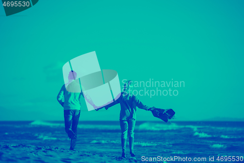 Image of Loving young couple on a beach at autumn sunny day