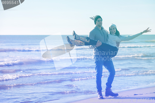 Image of Loving young couple on a beach at autumn sunny day