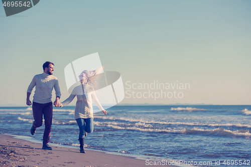 Image of Loving young couple on a beach at autumn sunny day