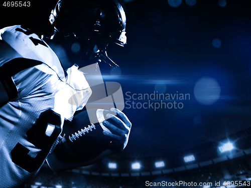 Image of American football player holding ball while running on field