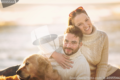 Image of Couple with dog enjoying time on beach