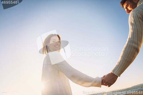 Image of Loving young couple on a beach at autumn sunny day