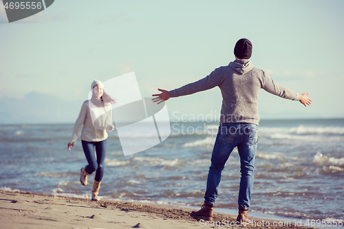 Image of Loving young couple on a beach at autumn sunny day