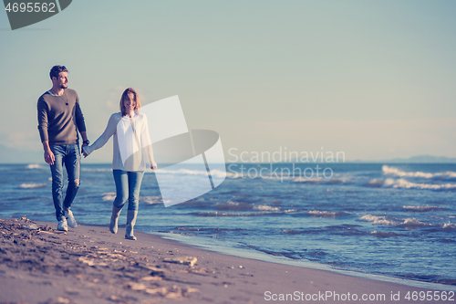 Image of Loving young couple on a beach at autumn sunny day