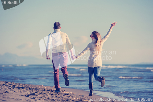 Image of Loving young couple on a beach at autumn sunny day