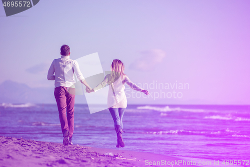 Image of Loving young couple on a beach at autumn sunny day