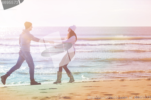 Image of Loving young couple on a beach at autumn sunny day