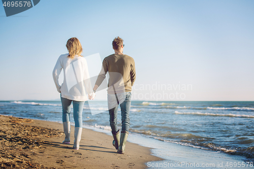 Image of Loving young couple on a beach at autumn sunny day