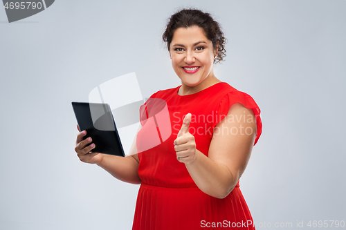 Image of happy woman with tablet computer showing thumbs up