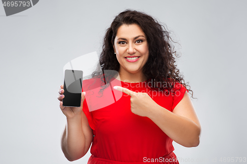 Image of happy woman in red dress showing smartphone