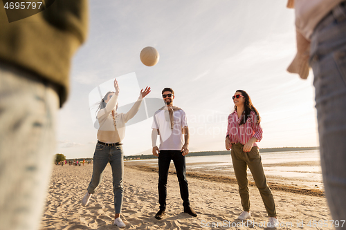 Image of friends playing volleyball on beach in summer