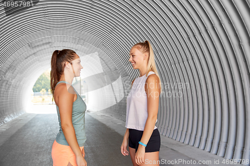 Image of sporty young women or female friends in tunnel