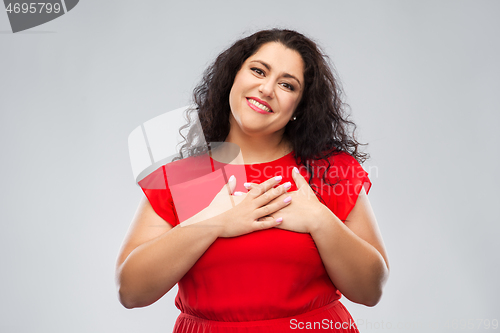 Image of happy woman holding hands on chest or heart