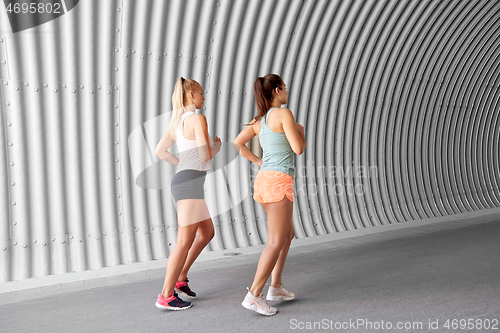 Image of young women or female friends running outdoors