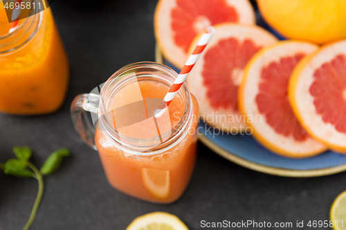 Image of mason jar glass of fruit juice with paper straw