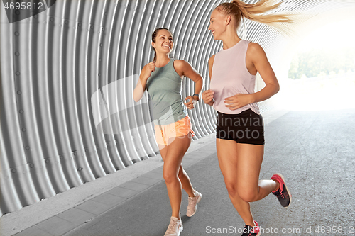 Image of young women or female friends running outdoors