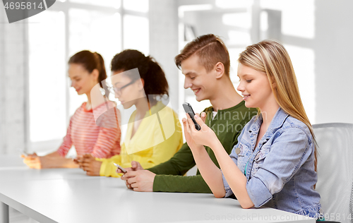 Image of happy high school students with smartphones