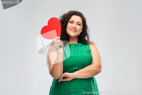 Image of happy woman in green dress holding red heart