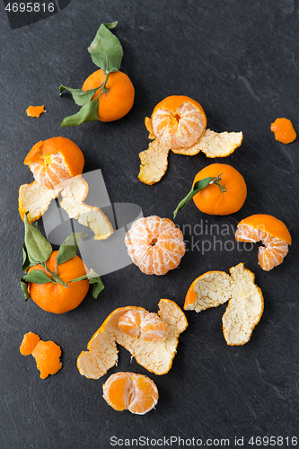 Image of close up of peeled mandarins on slate table top