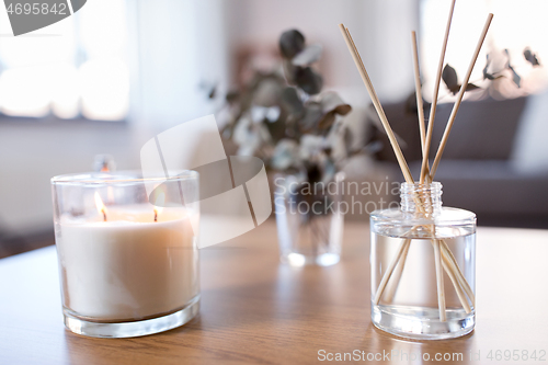 Image of aroma reed diffuser, burning candle and perfume