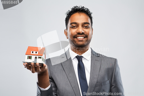 Image of indian man realtor with house model and folder